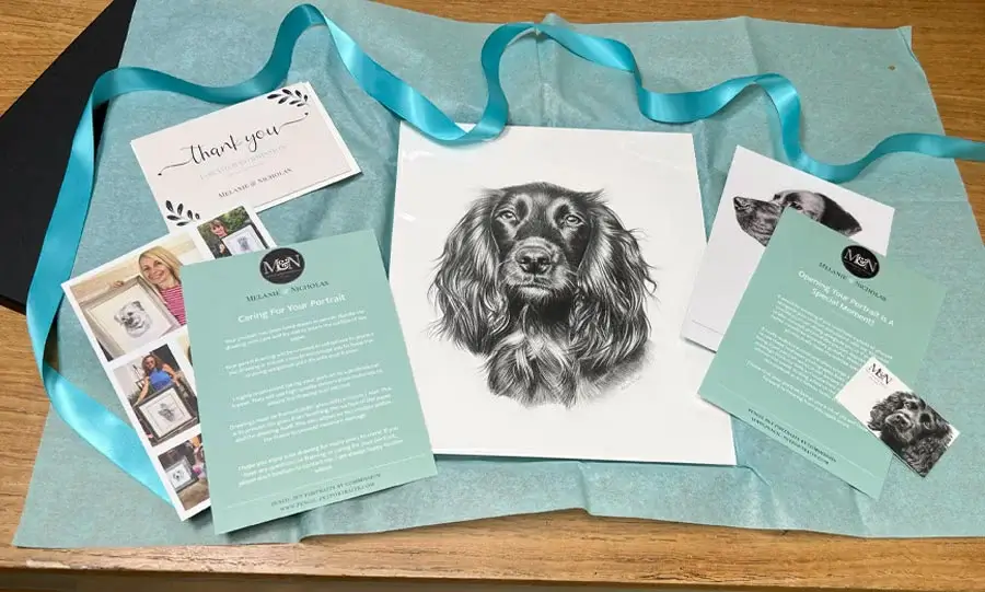 A carefully packaged pencil pet portrait in a presentation box with ribbon.