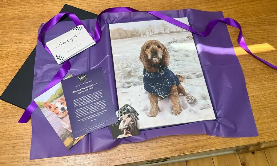 An open package showing a framed pet portrait nestled securely within protective foam.