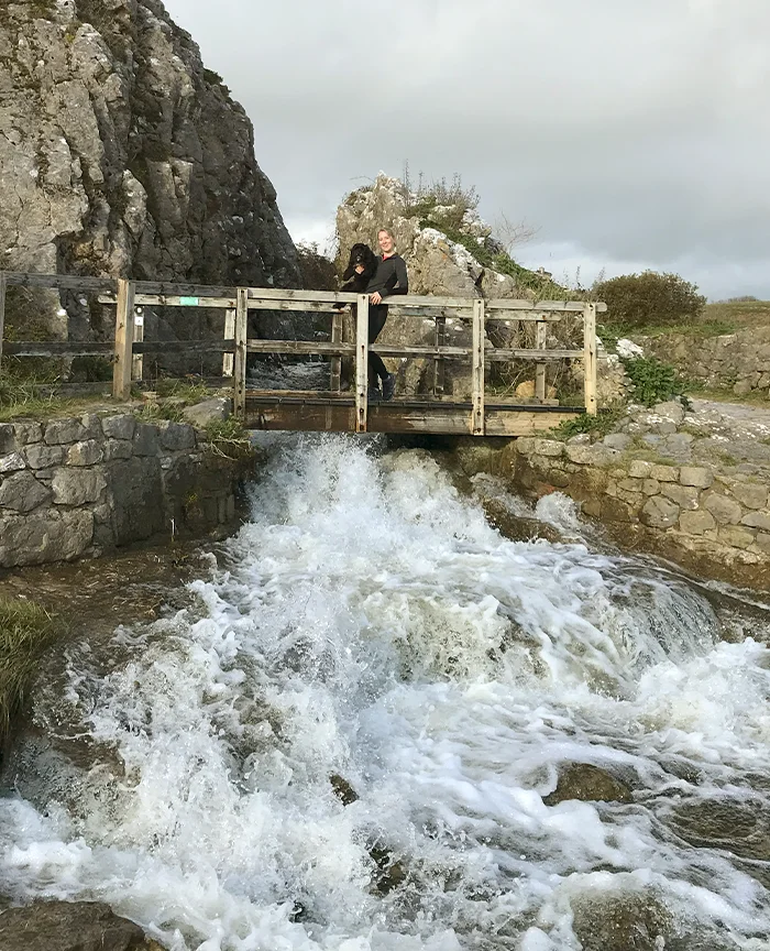 Melanie Phillips running energetically with Lily along the scenic coast near Stackpole, Pembrokeshire.
