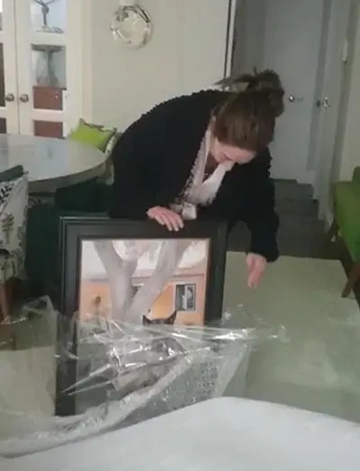 A client's mum joyfully holding her new pet portrait of Leya, praising its accurate likeness and the easy commissioning process.